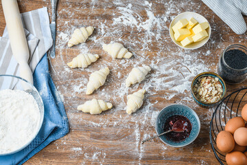 The chef manually makes croissants on the table with ingredients.