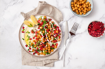 Vegetable salad with chickpeas, tahini sauce and pomegranate