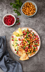 Vegetable salad with chickpeas, tahini sauce and pomegranate