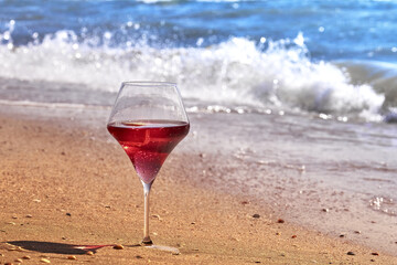 Wine glass with a cocktail by the sea.