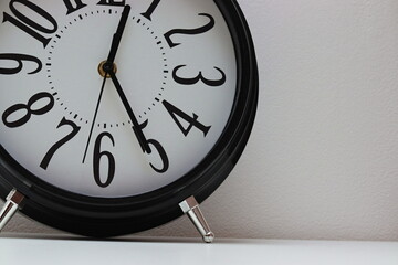 old retro clock white black on the table with large digits and teapots