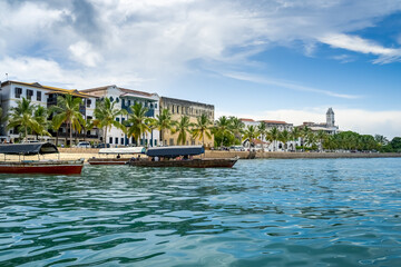 Fototapeta na wymiar The skyline of Stone Town in Zanzibar seen from the water. sunny day with clouds. travel concept with turquoise indian ocean