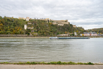 German corner, Koblenz were rivers Rhein and Mosel meet. A river barge in the foreground with the Ehrenbreitstein castle in the background
