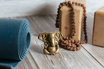 Close-up bronze statue of hindu god of success Ganesha. Japa Meditation accessories, mat and yoga...