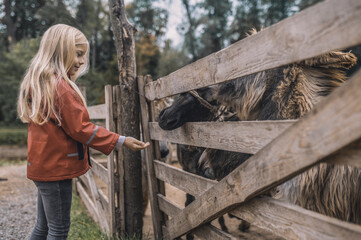 Blonde cute girl standing near the cattle-pen