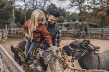 Farmer and his kid spending time with animals in the cattle-pen