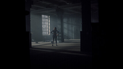 Fototapeta na wymiar Athlete standing in modern gym. Muscular woman holding skipping rope in hands
