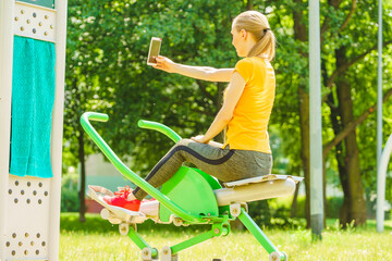 Girl doing exercises outdoor, taking selfie