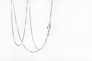 Silver chain hanging on a white background.