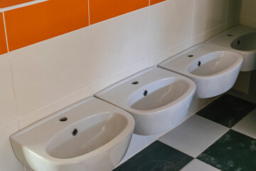 A system of numerous sinks installed in a public toilet. Applies to train station, cinema and other public place.