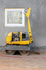 Fototapeta na wymiar Manual compact asphalt roller for tamping soil at a construction site.