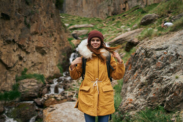 Naklejka premium woman in a jacket with a backpack hiking travel in the mountains