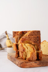 Front view of sliced banana bread on light concrete background, stacked pieces of cake