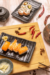 sushi platter set, nigiri, uramaki california roll with red hot peppers and black teapot