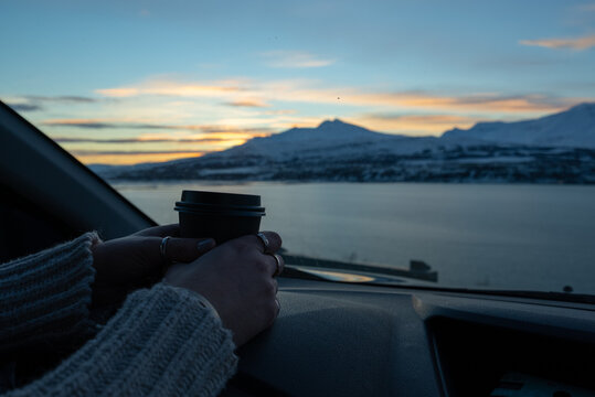 woman watching the sunset in cozy car with mountain landscape