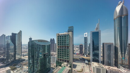 Dubai international financial center skyscrapers with cloudy blue sky aerial all day timelapse.