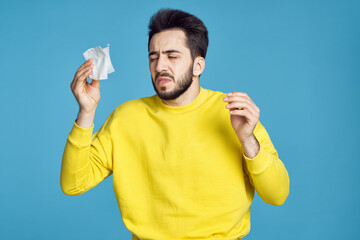 man in yellow sweater health problems emotions blue background