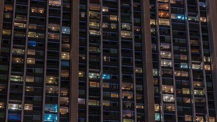 Fototapeta na wymiar Big glowing windows in modern office and residential buildings timelapse at night