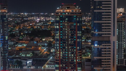 Fototapeta na wymiar Glowing windows and towers and villa houses on a background aerial night timelapse, Dubai, United Arab Emirates