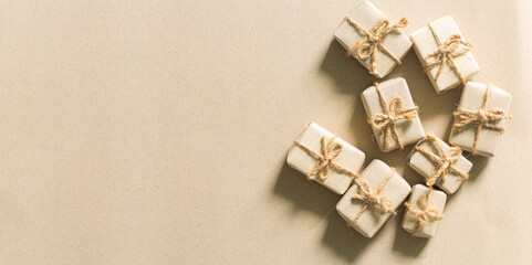 A brown gift box on a brown background,Christmas gift boxes wrapped with brown kraft paper and decorated with eucalyptus leaves, over brown background. Top view.