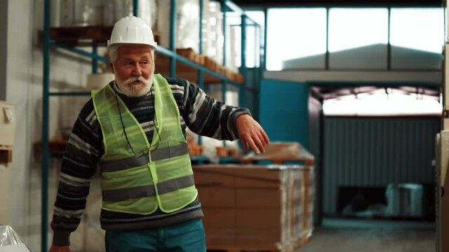 Tired drunk old warehouse worker standing and provokes colleagues by cursing them