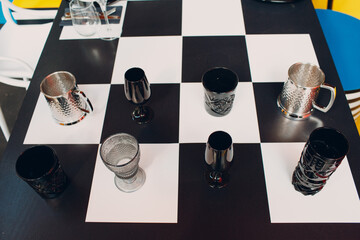 Wedding table decor like a chessboard with black and white dishes glasses.