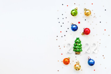 Christmas tree with colorful decorations. New Year 2022 festive symbols. Top view, flat lay with copy space.