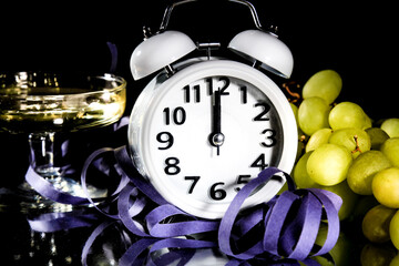 New Year at Midnight. Clock at twelve o'clock with holiday lights and grapes