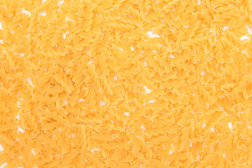 Uncooed Fusilli Pasta - Background. Texture of Bright Golden Dry Macaroni