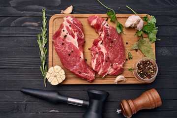 meat steak wooden board and spices ingredients top view