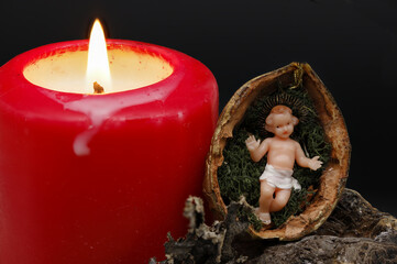 Krippe aus Wallnuss mit Jesukind und roter Kerze