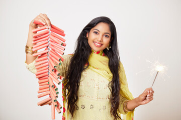 Indian pretty young woman celebrating Diwali festival with fire crackers.  