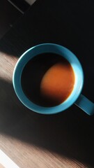 A coffee mug with the sun shining on it. Top view.