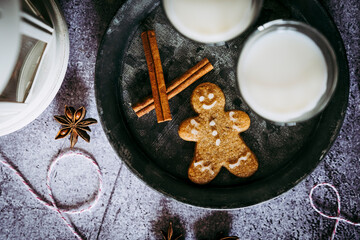 Bonhomme en pain d'épices à la cannelle et verres de lait sur une table de fête