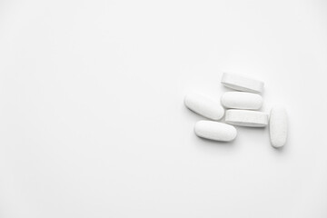Six white pills isolated on white background