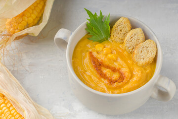Healthy diet. Delicious hot creamy corn soup on a light background. Food for vegans and vegetarians. Top view.
