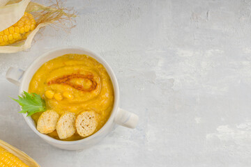 Delicious creamy corn soup on a light background. Food for vegans and vegetarians. Healthy diet. Top view. Copy space