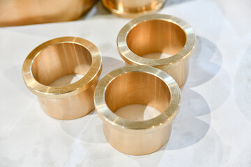 Three bronze bushings turned on a cnc lathe in a repair shop.