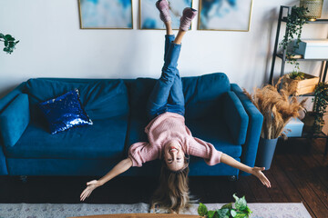 Girl laying with open arms on sofa at home