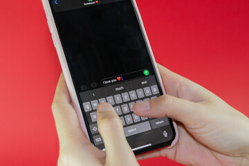 woman holding a smart phone and sending happy valentine's day