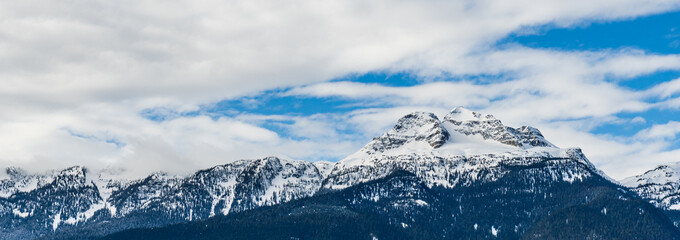 panorama of high mountains covered by snow cloudy blue sky british columbia canada