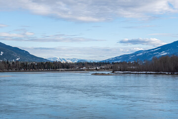 Obraz premium wide Columbia river with snow in mountains blue sky early spring British Columbia Canada
