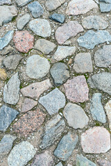 a fragment of a cobblestone pavement of different sizes and shapes. Close-up. Weathered surface