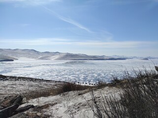 Obraz premium frozen lake with transparent ice on a blue sky background
