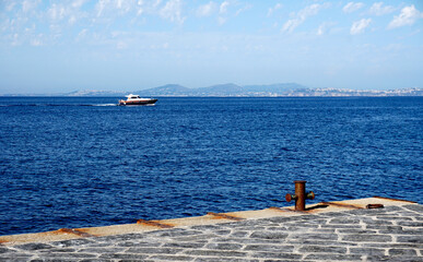 Seascape at the Amalfi coast with deep blue sea and a boat at the horizon