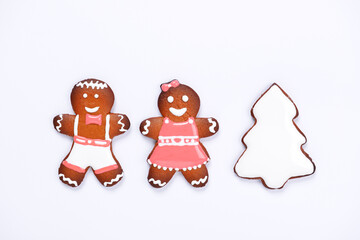The hand-made eatable gingerbread little men and New Year Tree on white background - 474070349