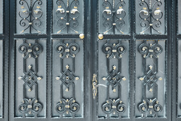 Black wrought metal doors decorated with golden ornaments