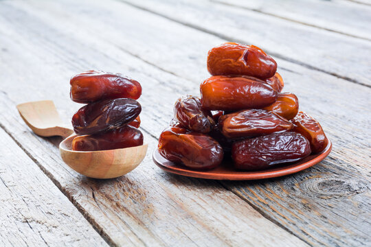 Dried dates in a plate on a wooden table