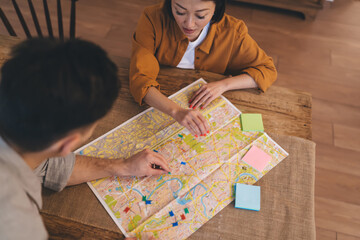Сouple choosing famous places on city map at table