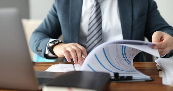 Businessman in suit filling out documents at table in office closeup 4k movie